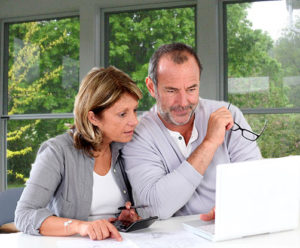 Couple calculating their retirement savings on computer
