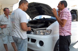 3 men repairing vehicle
