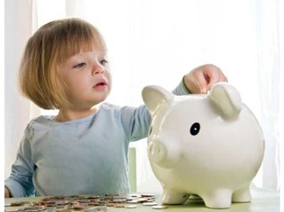 Girl pitting money into piggy bank