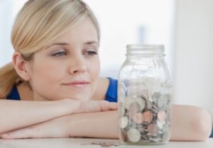 A young woman looking at a money jar