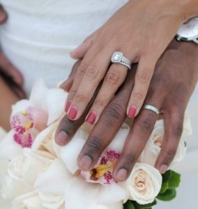 Man and woman holding hands wearing wedding rings