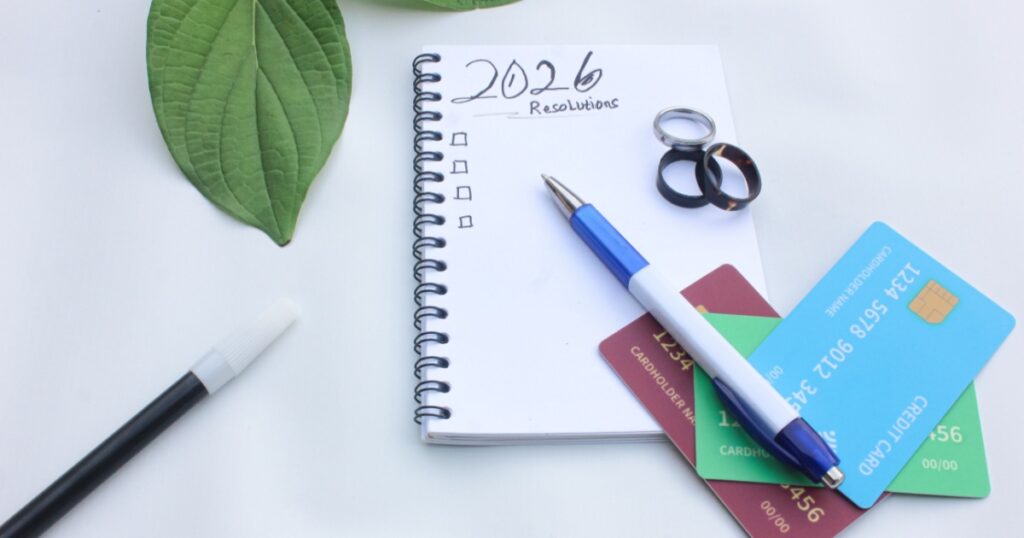 A notepad with the title 2026 resolutions and credit cards and a pen