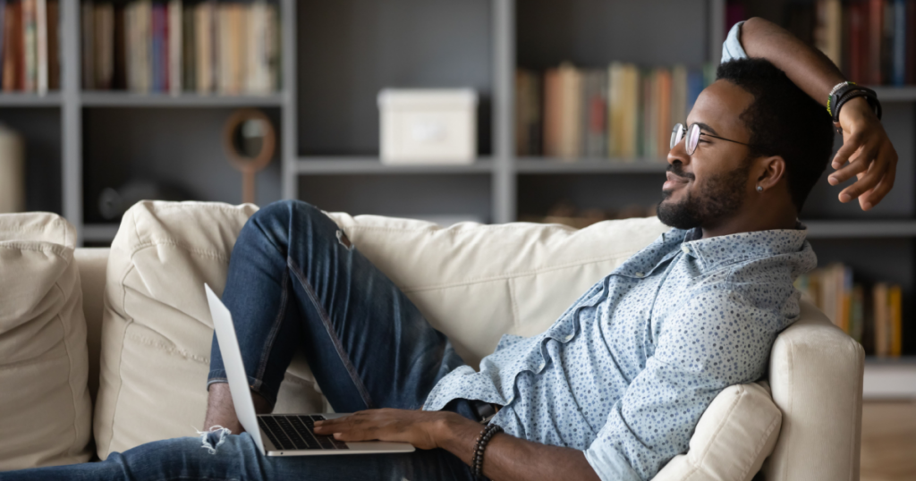 A relaxed looking black man sitting on a couch