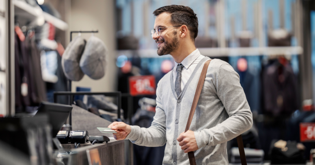a middle aged man offering a credit card to pay for something