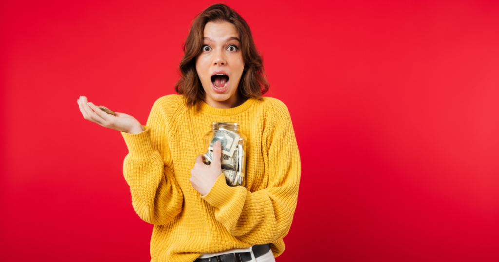 Girl holding a cash jar with a surprised look on her face.